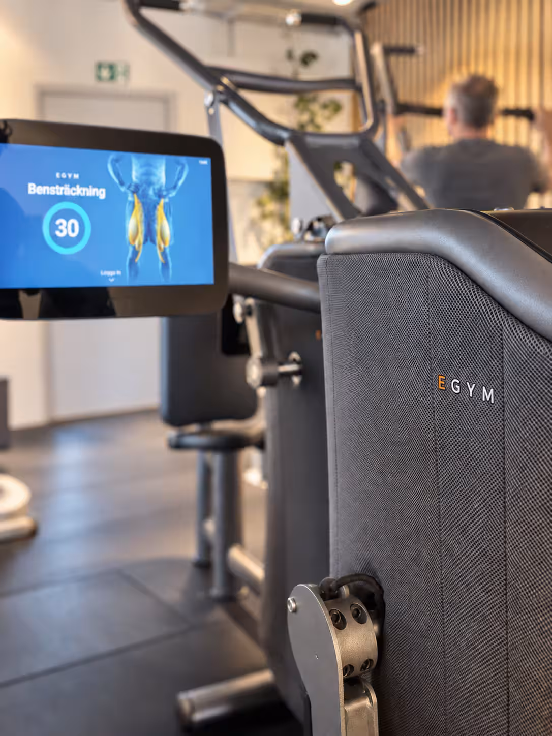 EGYM-märket och maskinens material med träning i bakgrunden